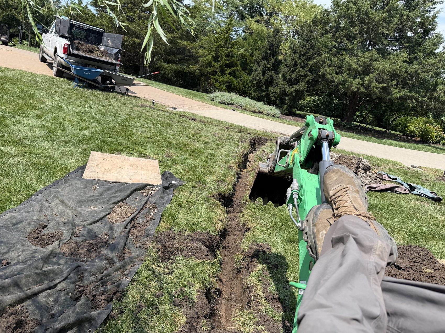 Mission Drainage crew trenching a French drain line with a mini excavator