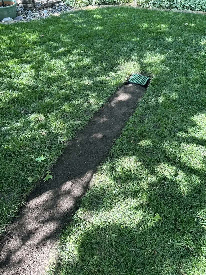Buried drainage line feeding an underground dry well in a Kansas City yard